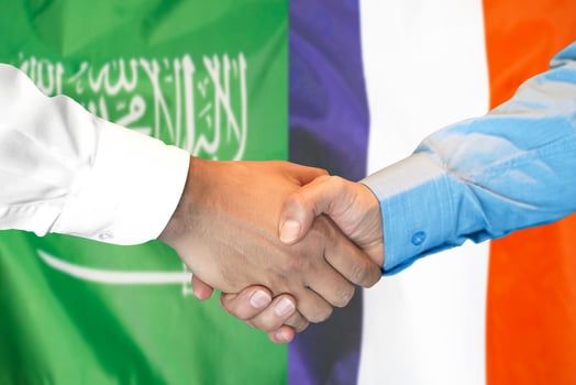 handshake on Saudi Arabia and France flag background. photo
