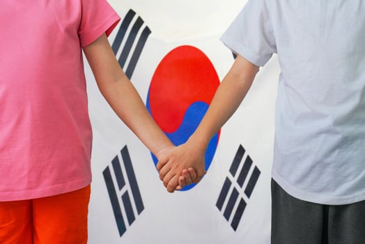 Boy and girl joined hands on background flag South Korea photo