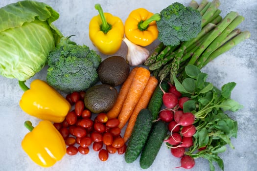 Top view of fresh colorful vegetables on a grey background. Concept of healthy eating, organic produce, and plant-based diet. Close-up photo