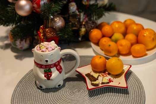Festive Christmas scene with a cute polar bear mug on a decorated table. Concept of cozy winter holidays, seasonal treats, and festive home atmosphere photo