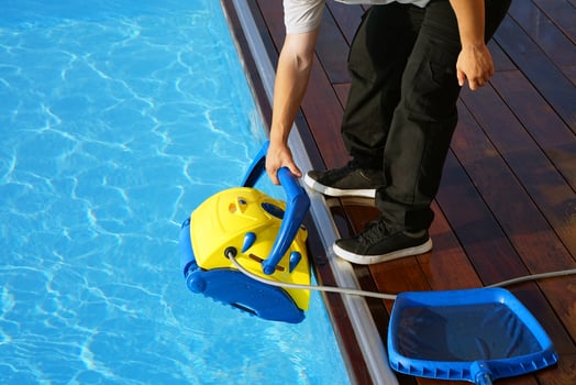 Hotel staff worker cleaning the pool. Automatic pool cleaners. photo