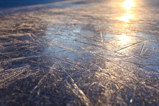 Snow-covered ice surface glistening in warm sunlight photo