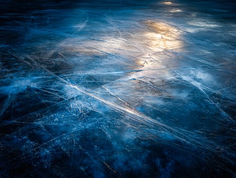 Glacial ice surface with reflections and intricate ice fractures photo