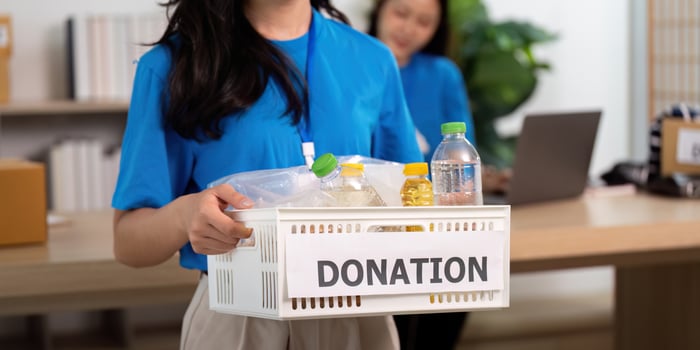 Volunteer holding a donation basket filled with essential items photo