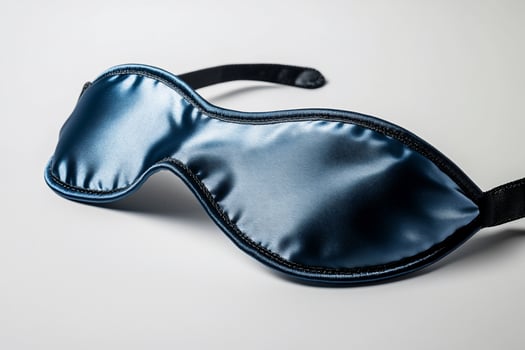 Blue satin sleep mask for restful sleep and relaxation on light background photo
