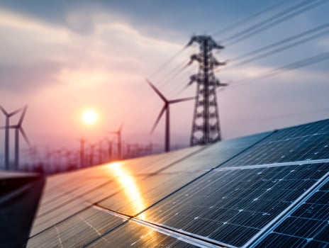 Renewable energy solutions featuring solar panels and wind turbines at sunset photo