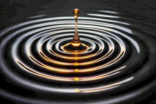 Close-up of a water droplet splash creating ripples in dark water photo
