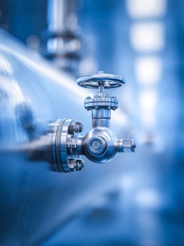 Industrial metallic valve on a large tank in a manufacturing plant photo