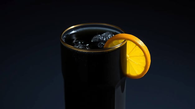 A black drink with an orange slice on top photo