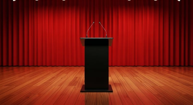 Empty stage with a black podium and microphones against a red curtain backdrop photo