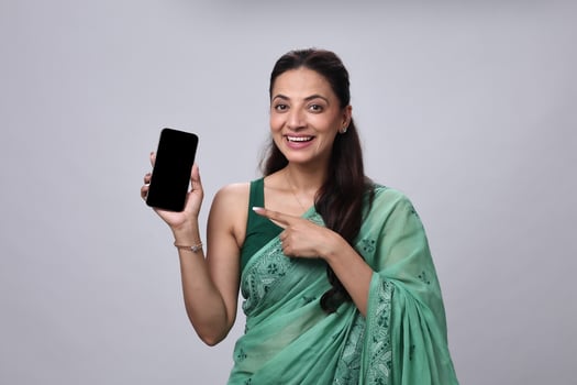 Woman holding smartphone in green saree photo