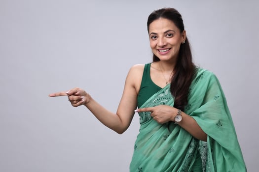 Woman pointing in a green saree photo