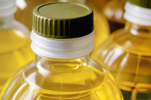 A row of bottles of sunflower oil in supermarket. The bottles are all the same size and shape photo