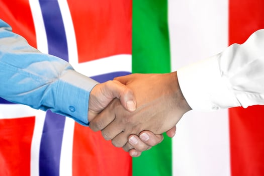 handshake on Norway and Italy flag background. photo