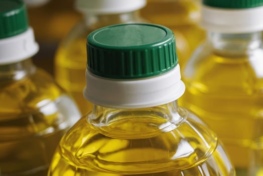 Row of bottles of sunflower oil in supermarket. The bottles are all the same size and shape photo
