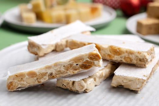 Close-up of a plate with hard turron or Alicante turron, served on a Christmas table. photo