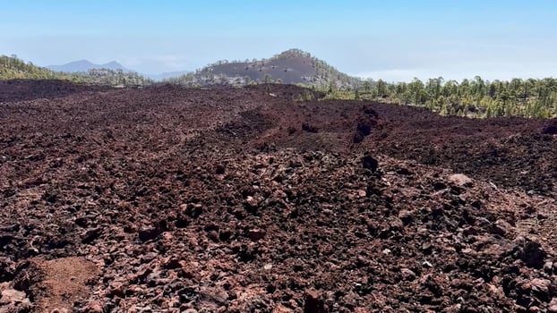 The Breathtaking Lava Field is Beautifully Surrounded by Scenic Hills in the Background photo