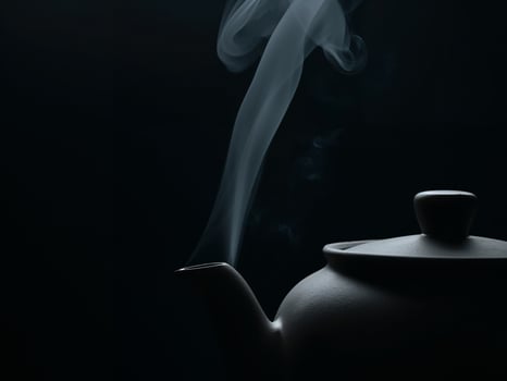 Minimalist Teapot with Rising Steam on Dark Backdrop, Tranquil and Serene Scene photo