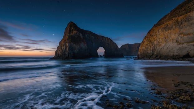 Serene twilight at a coastal arch, waves gently lapping at the shore, stars twinkling above photo