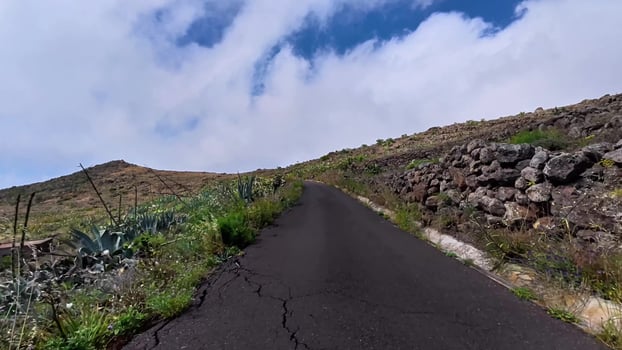 A majestic scenic mountain road surrounded by lush greenery and a clear blue sky above photo