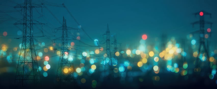 The powerlines silhouetted against a vibrant, illuminated city at night. photo