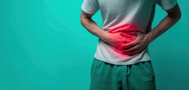 The man experiencing abdominal pain and discomfort on a turquoise background photo