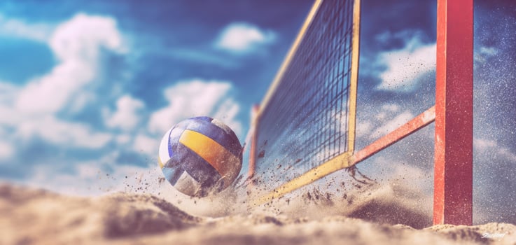 The volleyball soaring over the net on a sunny beach setting. photo