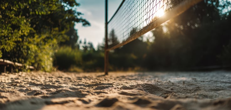 The volleyball net standing on a serene beach during sunset. photo