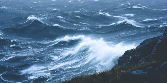 Large waves crashing against dark rocks on a stormy day photo