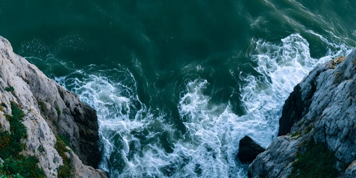 Ocean waves crashing against rocky cliffs photo