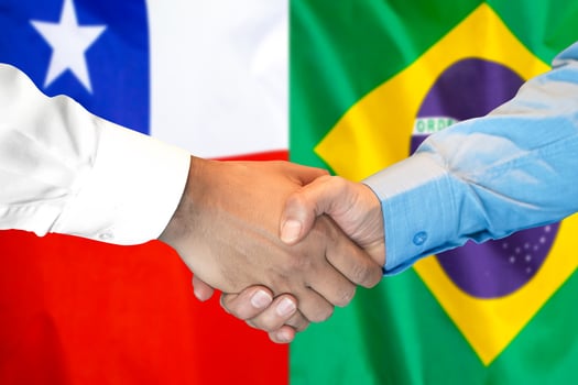 handshake on Chile and Brazil flag background. photo