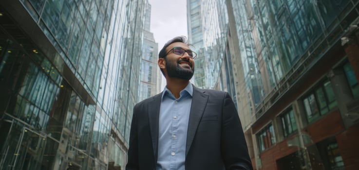 The confident businessman standing in a modern urban environment looking upwards. photo