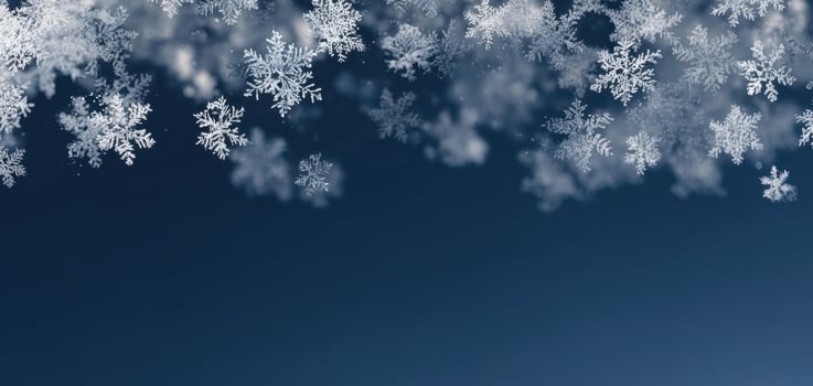 The delicate beauty of snowflakes drifting against a blue winter sky. photo