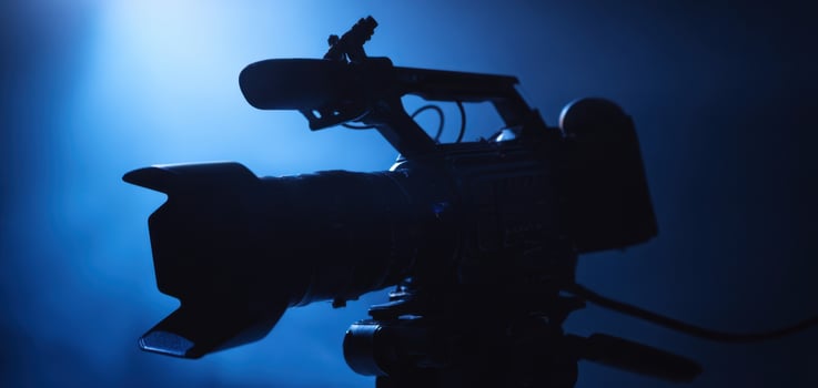 The cinematic camera silhouetted against dramatic blue lighting. photo