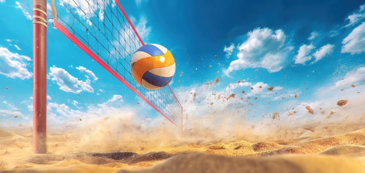 The volleyball soaring above the sandy beach towards the net under a bright sky photo