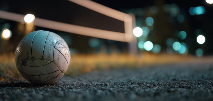 The volleyball resting on the ground illuminated by evening lights photo