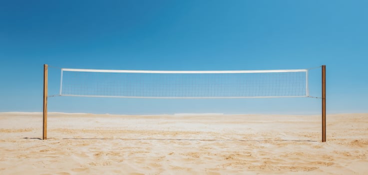 The volleyball net standing alone on a tranquil beach under a bright sky. photo