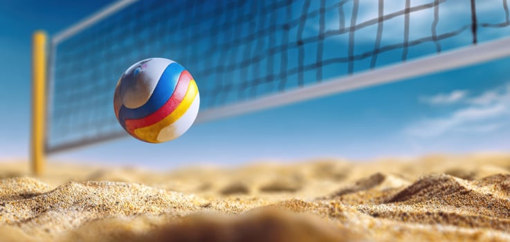 The volleyball soaring over the net in a sunny beach setting photo