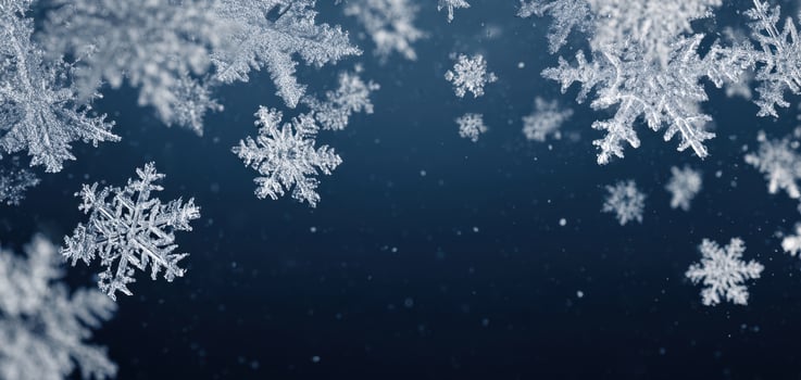 The mesmerizing beauty of delicate snowflakes falling against a blue backdrop. photo