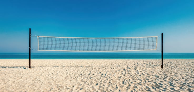 The volleyball net set against a picturesque beach and tranquil ocean backdrop. photo