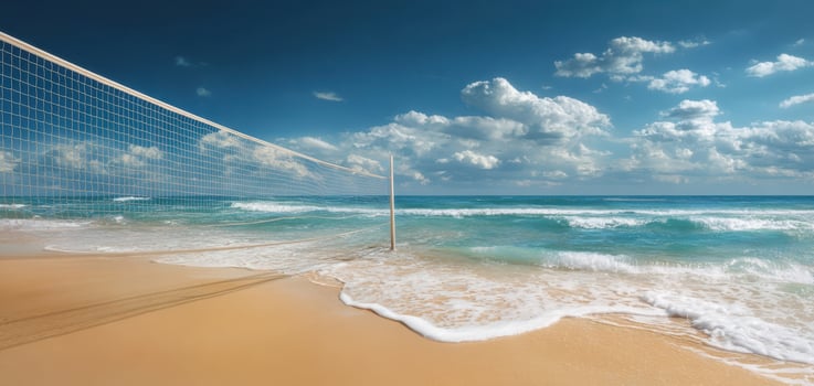 The beach volleyball net beside the sparkling ocean under a blue sky. photo
