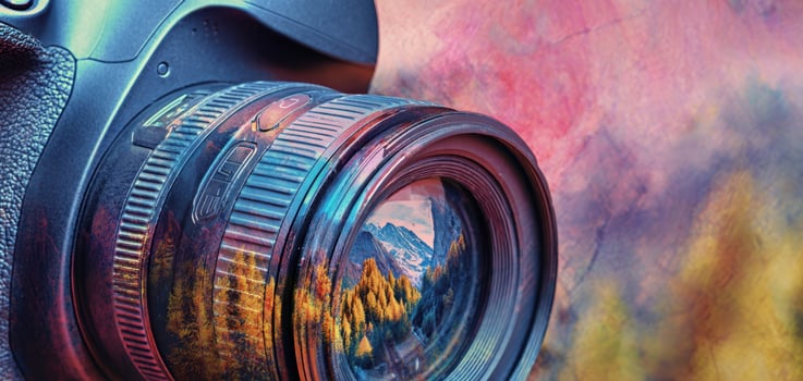 The Camera Reflecting a Colorful Mountain Landscape Through Its Lens photo