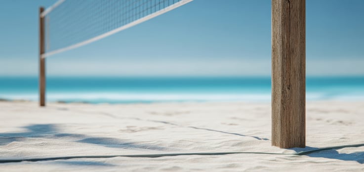 The volleyball net stands on a pristine beach with a stunning ocean backdrop. photo