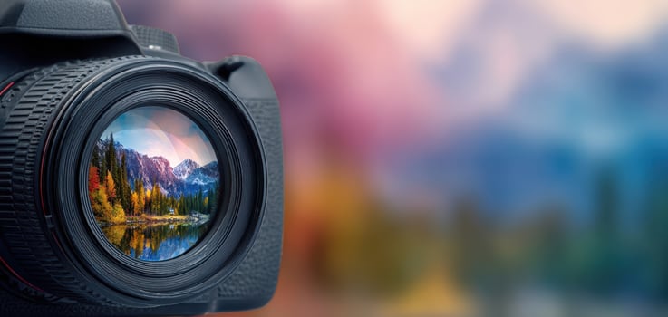 The camera lens capturing a vibrant landscape with colorful mountains and reflections. photo
