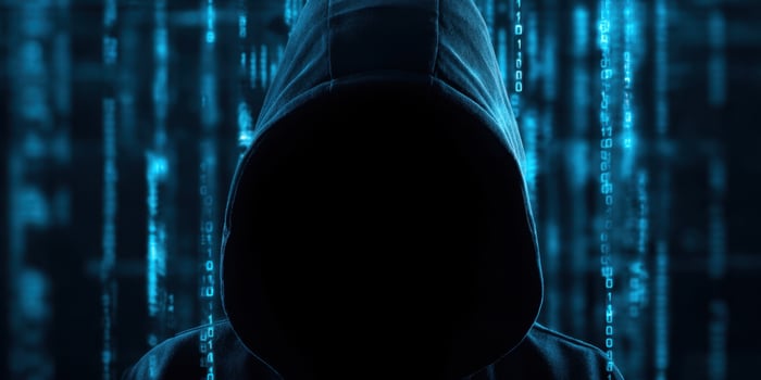 The mysterious hacker cloaked in shadows against a digital backdrop. photo