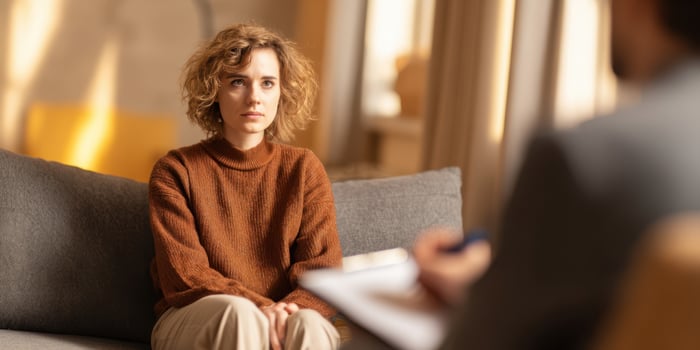 The woman engaged in therapy session with her attentive counselor photo