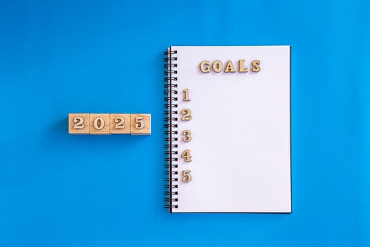 2025 New Year goal, plan, and action concepts. 2025 goals Text on Note Pad with calendar, glasses on the table.New Year's resolutions plan.Happy New Year theme, top view1 photo
