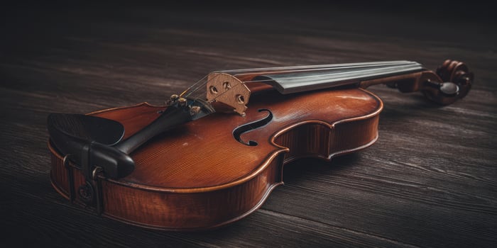 The elegant violin resting gracefully on a rustic wooden surface. photo