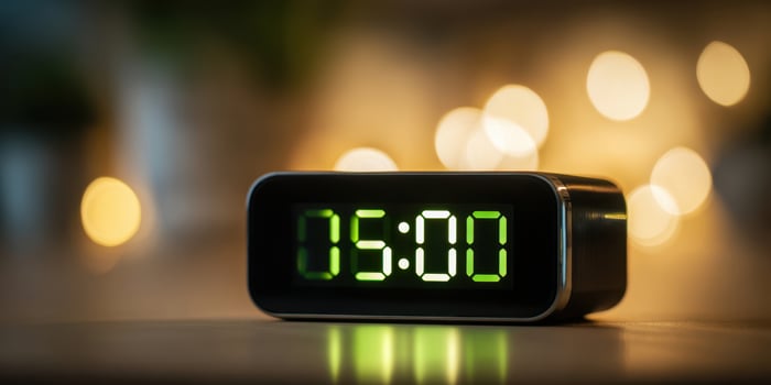 The digital alarm clock displaying five o'clock in a cozy atmosphere. photo