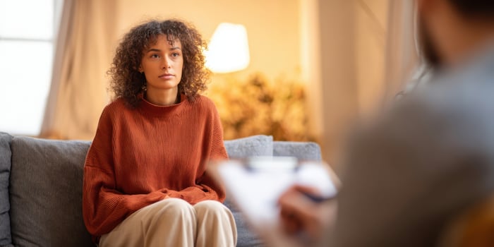The woman sitting on the couch during a therapeutic counseling session. photo